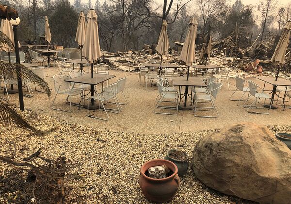 Кафейные столики и зонты Mama Celeste's Gastropub and Pizzeria после лесных пожаров (12 ноября 2018). Парадайз, Калифорния - Sputnik Армения