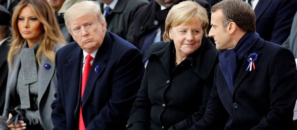 Президент США Дональд Трамп наблюдает, как президент Франции Эммануэль Макрон беседует с канцлером Германии Ангелой Меркель во время церемонии празднования Дня перемирия, спустя 100 лет после окончания Первой мировой войны (11 ноября 2018). Париж - Sputnik Армения