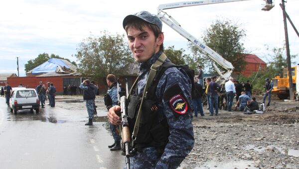 Полицейский в оцеплении места взрыва в селении Серноводск Сунженского района (16 сентября 2013). Чечня - Sputnik Армения