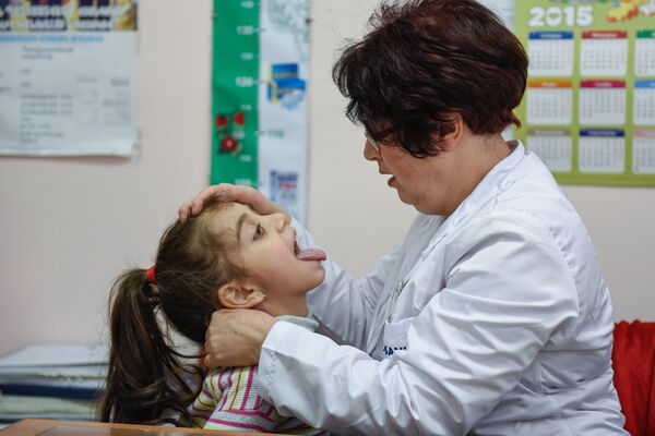 Բժշկուհին զննում է հիվանդ երեխային Բժշկուհին զննում է հիվանդ երեխային - Sputnik Արմենիա