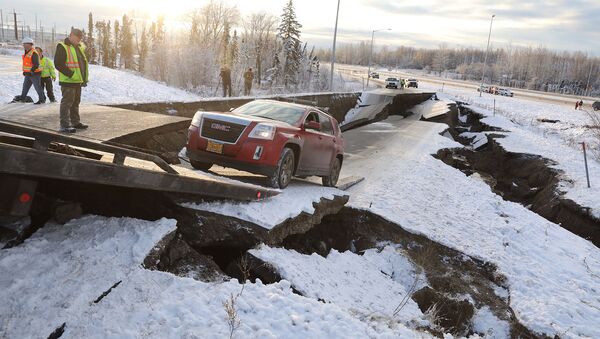 Спасатели вытаскивают застрявший автомобиль из разрушенного участка проезжей части возле аэропорта после землетрясения в Анкоридже (1 декабря 2018). Аляска - Sputnik Արմենիա
