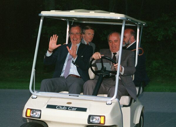 Президент СССР Михаил Горбачев подвозит президента США Джорджа Буша в гольф-каре к вертолету, для обратного вылета в Вашингтон (2 июня 1990). Кэмп-Дэвид, США - Sputnik Армения