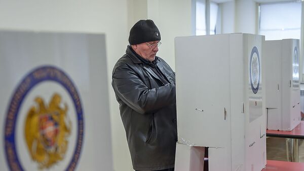 Избиратель на участке во время голосования  - Sputnik Армения