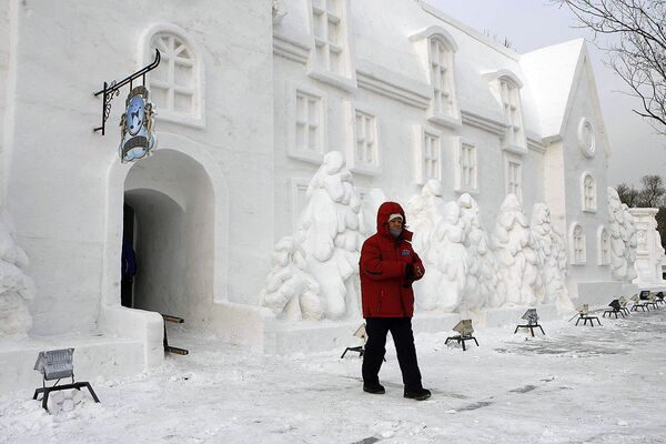 Женщина перед снежным домом в парке города Харбин (6 января 2007). Китай - Sputnik Армения