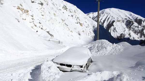 Заваленный снегом автомобиль на обочине автомобильной дороги Транскавказской магистрали в Северной Осетии, перекрытой из-за схода снежных лавин - Sputnik Армения