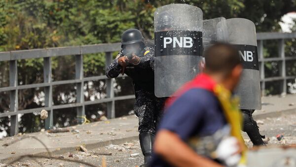 Сотрудник Национальной полиции Венесуэлы стреляет резиновыми пулями во время акции протеста против правительства президента Николаса Мадуро (23 января 2019). Каракас - Sputnik Армения
