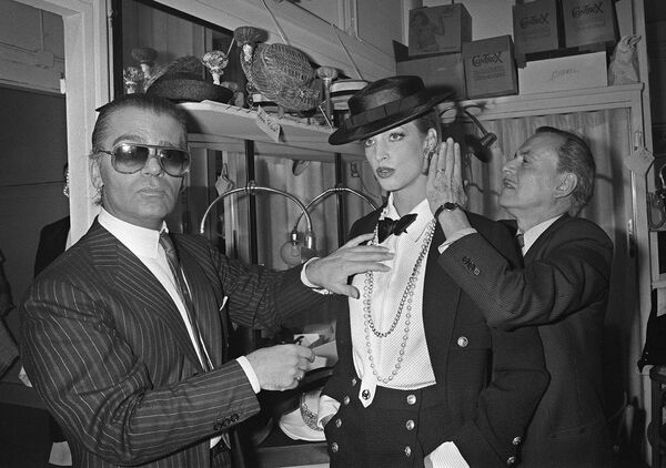 Модельер Карл Лагерфельд и парикмахер Александр де Пари готовят модель за кулисами в преддверии презентации весенне-летней коллекции haute couture для Chanel (24 января 1983). Париж - Sputnik Армения