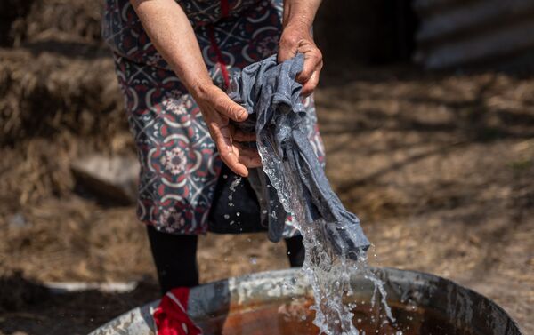 Արմավիրի մարզի Լենուղի համայնքի 4-րդ կարգի վթարային շենքերից մեկի բնակիչ Անուշ Իվանյանը՝ դրսում լվացք անելիս - Sputnik Արմենիա