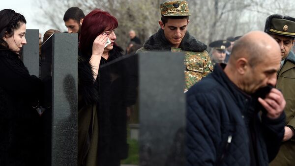 Родственники павшего в апрельской войне военнослужащего Григора Арутюняна у могилы в военном пантеоне Ераблур (2 апреля 2019). Еревaн - Sputnik Армения