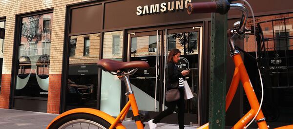 Женщина со смартфоном проходит мимо магазина Samsung в Нижнем Манхэттене (11 октября 2016). Нью-Йорк - Sputnik Արմենիա