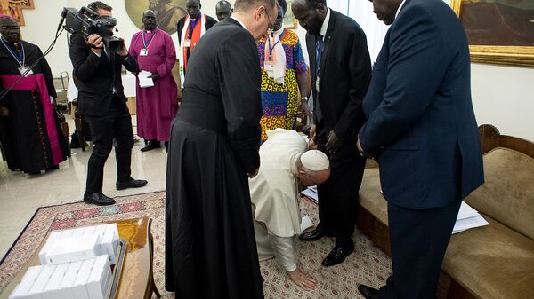 Римский Папа Франциск преклоняет колени, чтобы поцеловать ноги президента Южного Судана Сальвы Киира в конце двухдневного духовного ретрита с лидерами Южного Судана (11 апреля 2019). Ватикан - Sputnik Արմենիա