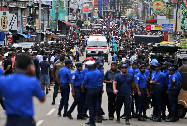 Сотрудники полиции Коломбо освобождают дорогу для кареты скорой помощи, на которой перевозят раненых от взрывов в (21 апреля 2019). Шри-Ланка - Sputnik Армения