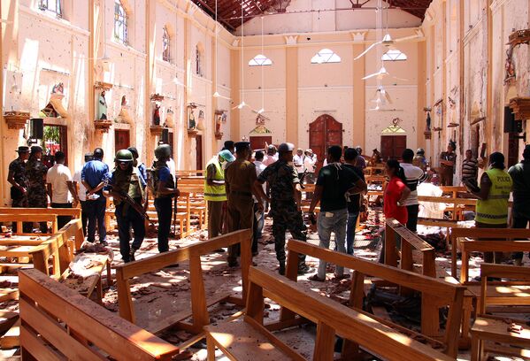 Сотрудники Службы безопасности Шри-Ланки проходят через обломки после взрыва в церкви Святого Себастьяна в Негомбо, к северу от столицы Коломбо (21 апреля 2019). Шри-Ланка - Sputnik Армения