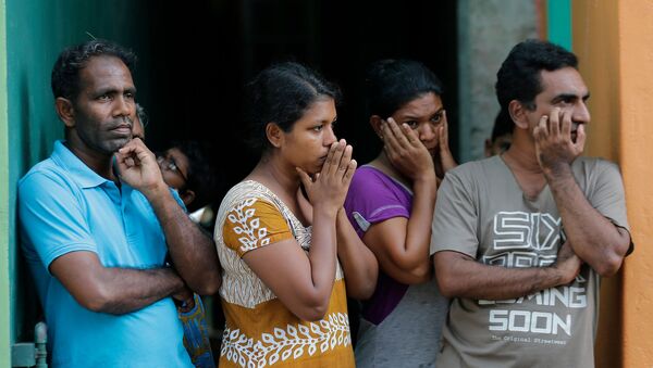 Шри-ланкийцы наблюдают, как сотрудники сил безопасности осматривают подозрительный автомобиль, припаркованный возле святыни Святого Антония, прежде чем он взорвался в Коломбо (22 апреля 2019). Шри-Ланка - Sputnik Արմենիա