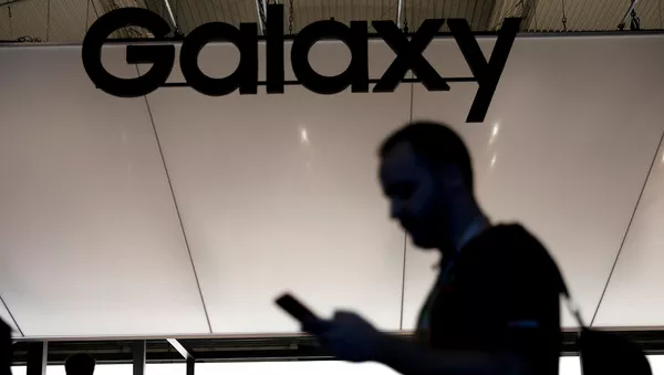 Посетитель со смартфоном на стенде Samsung на Mobile World Congress (26 февраля 2019). Барселона - Sputnik Армения