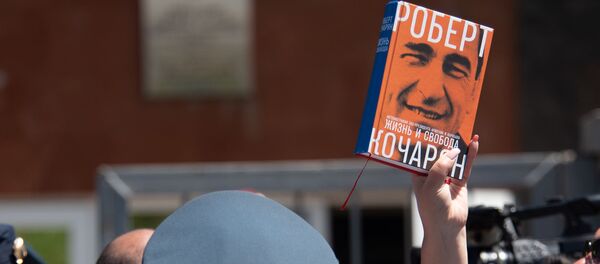 Сторонница Роберта Кочаряна с книгой Жизнь и свобода перед зданием суда общей юрисдикции столичных административных районов Аван и Нор Норк (15 мая 2019). Еревaн Сторонница Роберта Кочаряна с книгой Жизнь и свобода перед зданием суда общей юрисдикции столичных административных районов Аван и Нор Норк (15 мая 2019). Еревaн - Sputnik Արմենիա