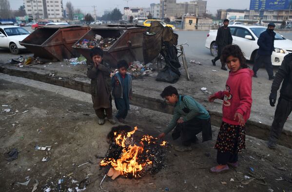 Афганские дети жгут пластик, чтобы согреться у костра на обочине дороги в Кабуле - Sputnik Армения
