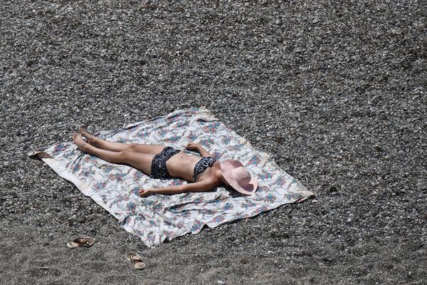 Девушка загорает на пляже возле мыса Меганом в Крыму - Sputnik Армения
