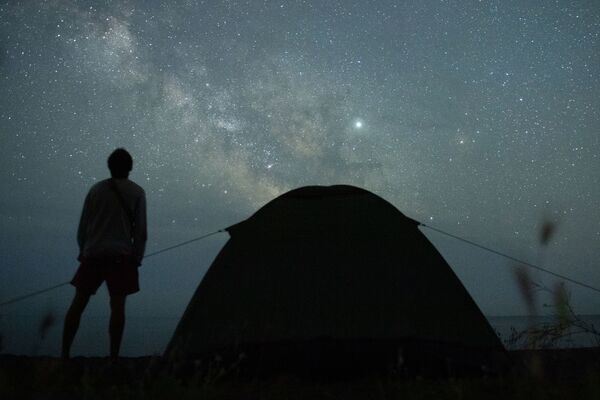 Мужчина наблюдает за звездным небом на берегу Черного моря возле поселка Морское в Крыму - Sputnik Армения