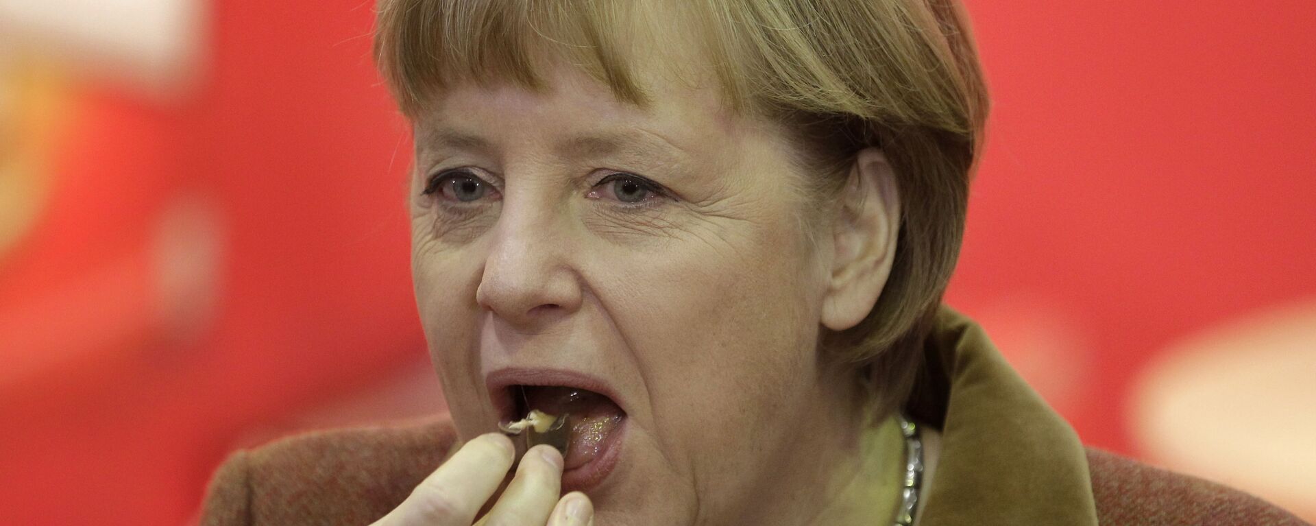 Канцлер Германии Ангела Меркель во время поедания кусочка шоколада - Sputnik Армения, 1920, 17.11.2021