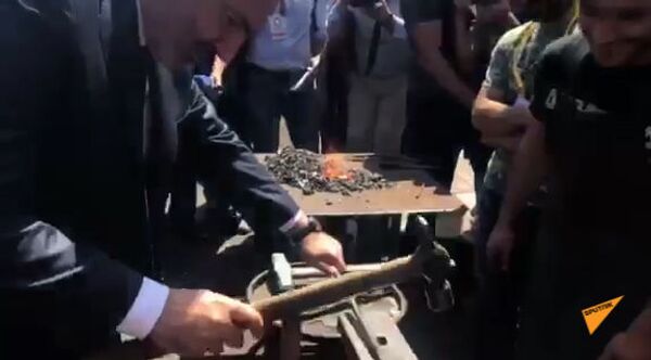 Премьер министр Армении Никол Пашинян мастерит металлическое изделие на выставке - Sputnik Армения