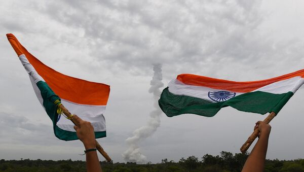 Индийские жители размахивают национальныe флагами после запуска Chandrayaan-2 (22 июля 2019). Срихарикот, Индия - Sputnik Армения