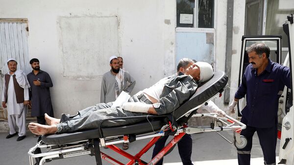 Спасатели помогают раненого мужчину после взрыва в Кабуле (7 августа 2019). Афганистан - Sputnik Արմենիա