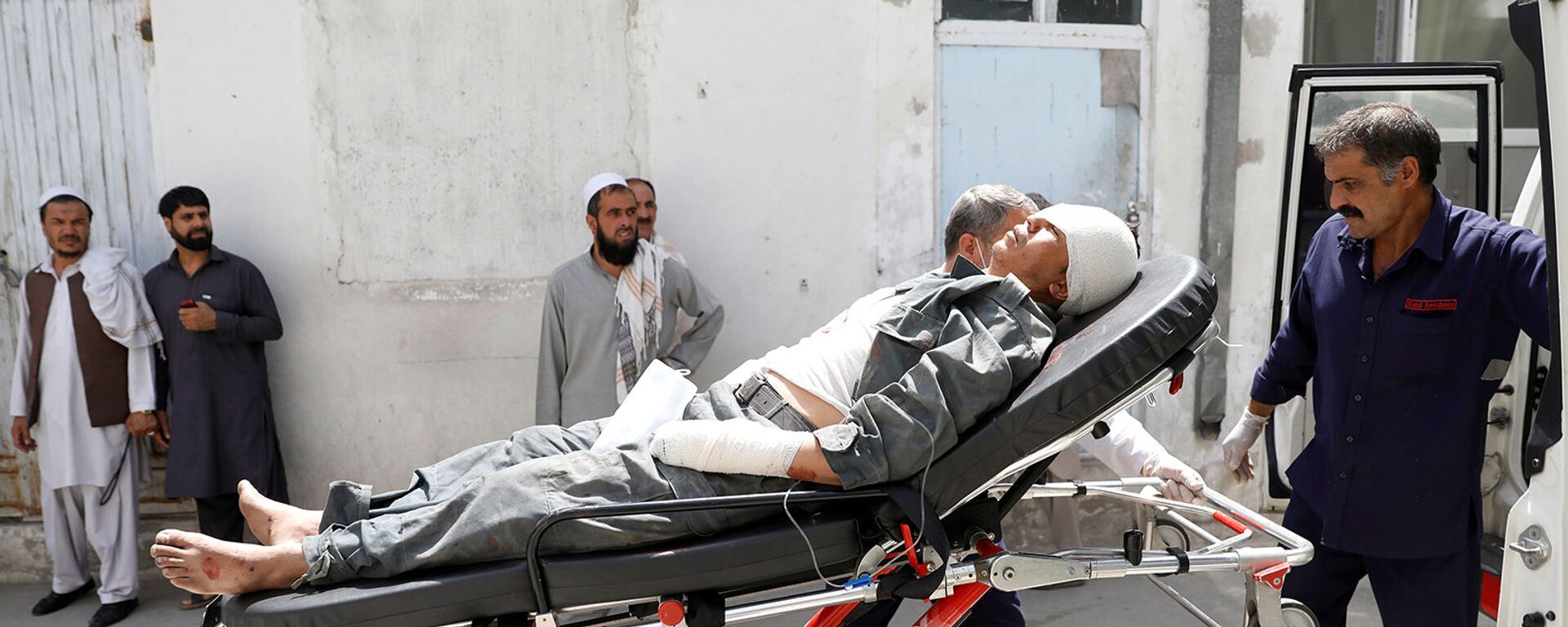 Спасатели помогают раненого мужчину после взрыва в Кабуле (7 августа 2019). Афганистан - Sputnik Армения, 1920, 11.12.2021