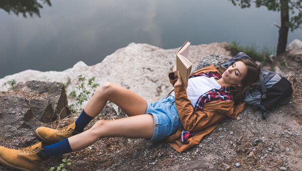 Женщина, одетая для горных путешествий, отдыхает и читает книгу - Sputnik Армения