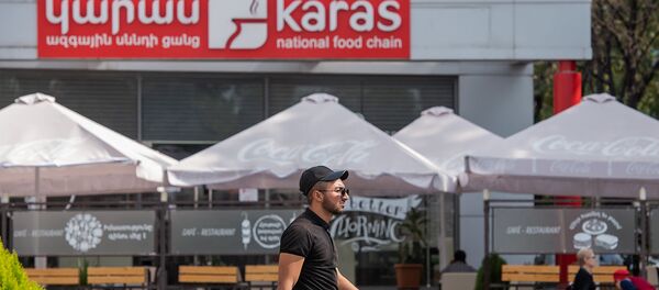 Молодой человек проходит около ресторана Карас - Sputnik Արմենիա