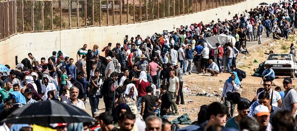 Сирийские беженцы ждут у ворот недалеко от города Килис (28 августа 2017). Турция - Sputnik Армения