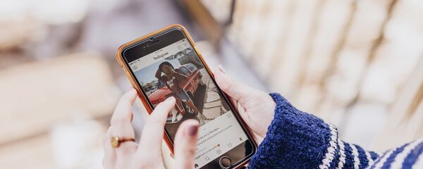 Девушка держит в руках смартфон с открытым приложением Instagram - Sputnik Արմենիա