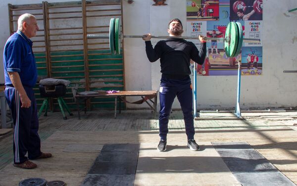 Заслуженный тренер по тяжелой атлетике Феликс Алиев наблюдает за тренировкой Карена Маркаряна - Sputnik Армения