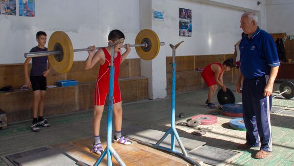 Заслуженный тренер по тяжелой атлетике Феликс Алиев наблюдает за тренировкой юных спортсменов в школе тяжелоатлетов села Гехакерт - Sputnik Армения