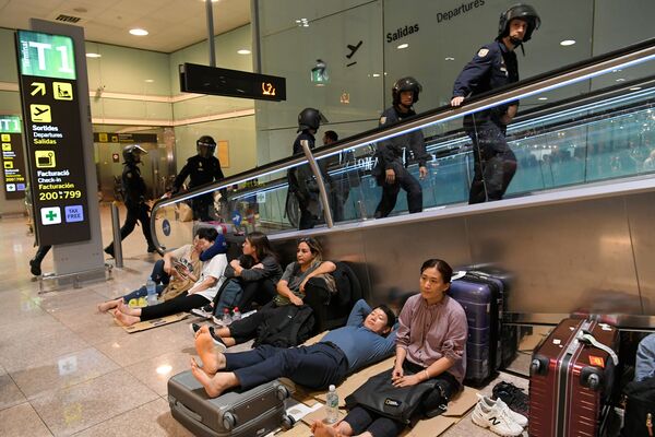 Испанские полицейские и пассажиры в аэропорту Барселоны, работа которого была парализована протестующими за независимость Каталонии - Sputnik Армения