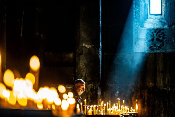 Верующий в монастыре Гегард в Котайкской области Армении. - Sputnik Армения