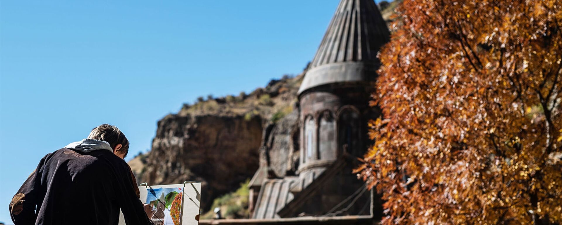 Молодой художник рисует монастырь Гегард в Котайкской области Армении. - Sputnik Армения, 1920, 05.02.2021