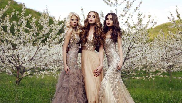 Три красивые девушки с длинными волосами и макияжем, одетые в вечерние платья, позируют в весеннем саду - Sputnik Армения