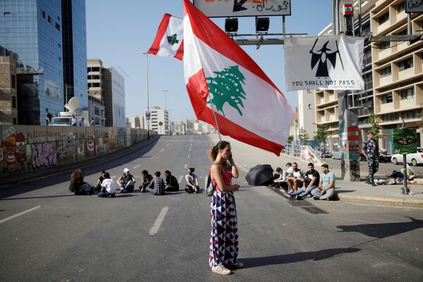 Женщина с флагом Ливана во время антиправительственных протестов в Бейруте - Sputnik Армения
