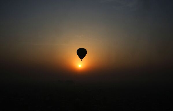 Во время фестиваля воздушных шаров в Лакхнау огромные и яркие воздушные шары наполняются воздухом и взлетают в небо на закате - Sputnik Армения