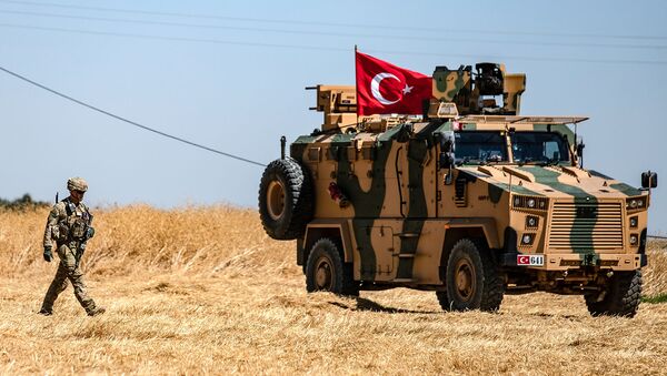 Американский солдат идет рядом с турецкой военной машиной во время совместного патрулирования с Турцией в сирийской деревне Аль-Хашиша на окраине города Таль-Абьяд вдоль границы с Турцией (8 сентября 2019). Сирия - Sputnik Արմենիա