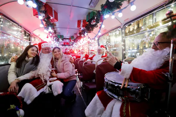 Музыканты в костюмах Санта-Клауса в автобусе в Санкт-Петербурге 
