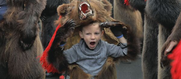 Зевающий мальчик в костюме медведя на новогоднем шествии в румынском городе Комэнешти - Sputnik Армения