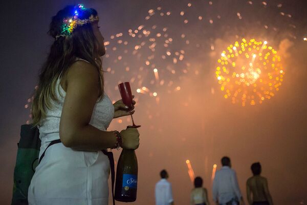Женщина наблюдает за фейерверком на пляже Копакабана во время празднования Нового года в Рио-де-Жанейро, Бразилия - Sputnik Армения