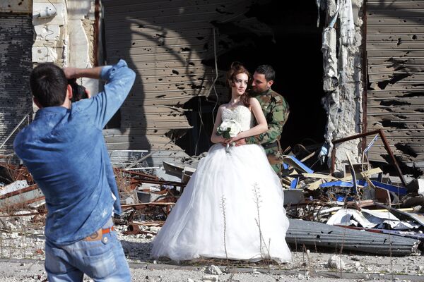 Сирийские молодожены во время фотосессии на фоне разрушенных зданий в Хомсе  - Sputnik Армения