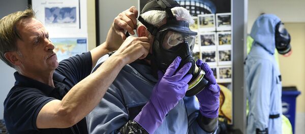 Мужчина примеряет воздухопроницаемый костюм, пропитанный древесным углем, в штаб-квартире ОЗХО (Организация по запрещению химического оружия) в Гааге (20 апреля 2017).  - Sputnik Արմենիա