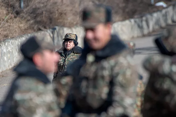 Сотрудница одной из воинских частей проходит мимо празднующих демобилизацию солдат Сотрудница одной из воинских частей проходит мимо празднующих демобилизацию солдат - Sputnik Армения