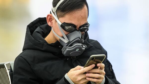 Пассажир в плавательных очках и маске на станции скоростного поезда, соединяющего Гонконг с материковым Китаем, во время новогодних праздников (28 января 2020). Гонконг - Sputnik Армения