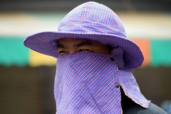 Мужчина в маске у рынка в Пномпене после того, как в стране был зарегистрирован первый случай нового коронавируса (30 января 2020). Камбоджа - Sputnik Армения