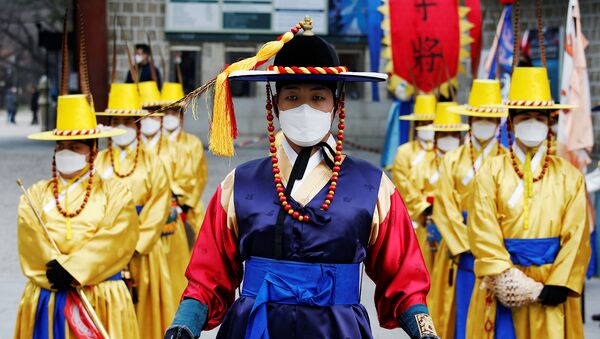 Рабочие в корейских традиционных костюмах и защитных масках во время реконструкции церемонии смены Королевской гвардии перед Дворцом Деоксу (31 января 2020). Сеул - Sputnik Արմենիա